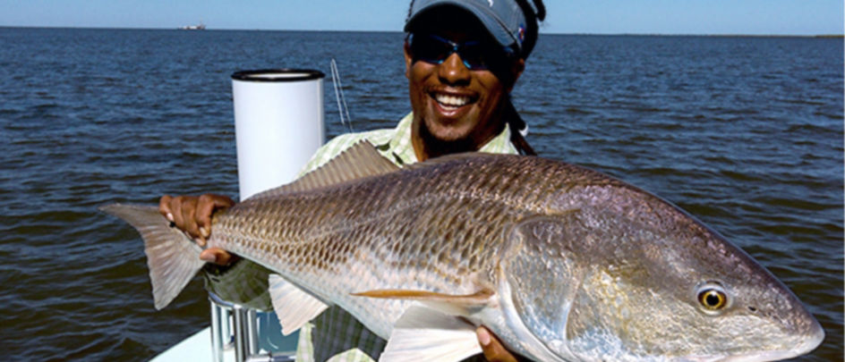 Man holding a Redfish out on the water